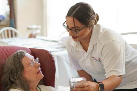 nurse giving patient a drink